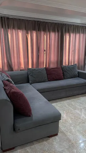 كنبة زاوية (L-Shape) رمادية بحالة ممتازة مع وسائد إضافية