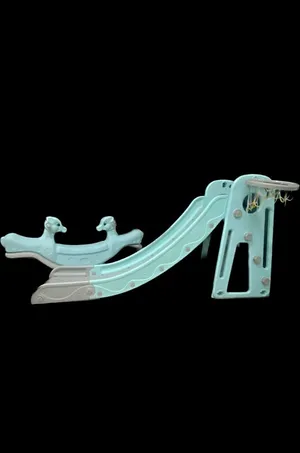 حصان هزاز و زلاقة مزودة بحلقة كرة سلة مدمجة. A rocking horse and a slide with a basketball hoop.
