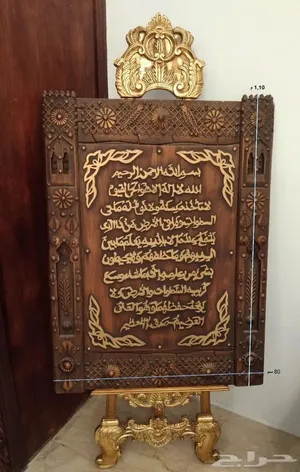 آية الكرسي بخط يدوي بارز على الخشب وإطار من النحاس مع حامل خشبي باللون الذهبي