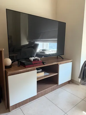 Brand-new 55-inch TV with a shatter-resistant screen, PlayStation 4, two controllers, and a TV unit.