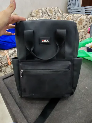 حقيبة ظهر سوداء من ماركة فيلا (FILA)، وتتميز بتصميمها العملي الذي يجمع بين حقيبة الظهر وحقيبة اليد