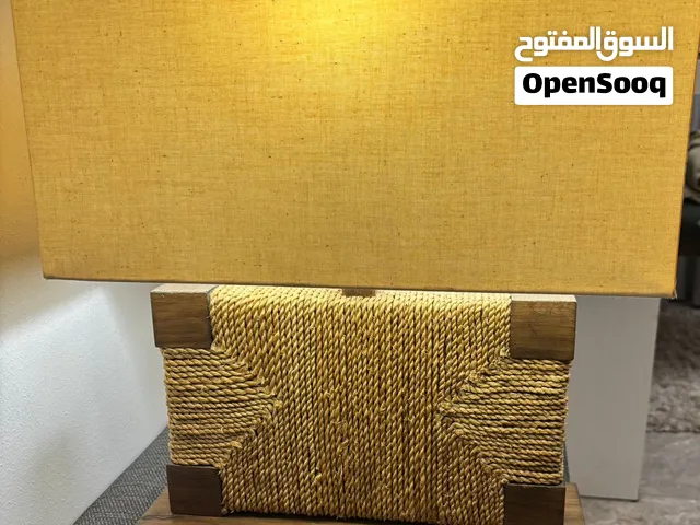 أباجورة أو مصباح طاولة (Table Lamp)، وتتميز بتصميم خشبي ريفي (Rustic) مزين بحبل ملفوف يحيط بالقاعدة
