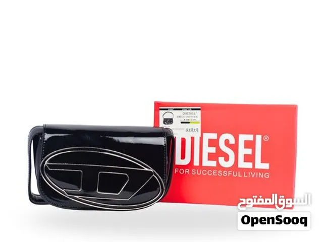 هذه حقيبة كتف نسائية سوداء من ماركة ديزل (Diesel) بتصميم أنيق ومزودة بشعار معدني فضي بارز على الواجه
