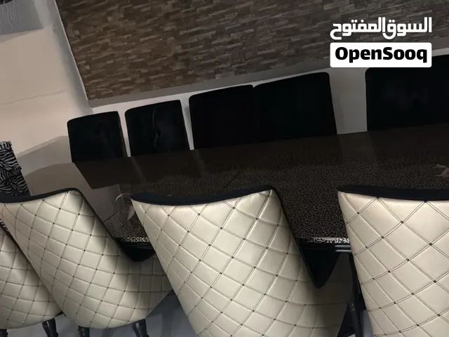 طاولة طعام راقيه وفاخره بنقشة التايقر مع لونها الأسود وكراسي اسود بجلد لون ذهبي