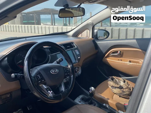 سيارة كيا ريو 2013 كوبيه فضي مع حساسات خلفية وداخل بني بحالة ممتازة