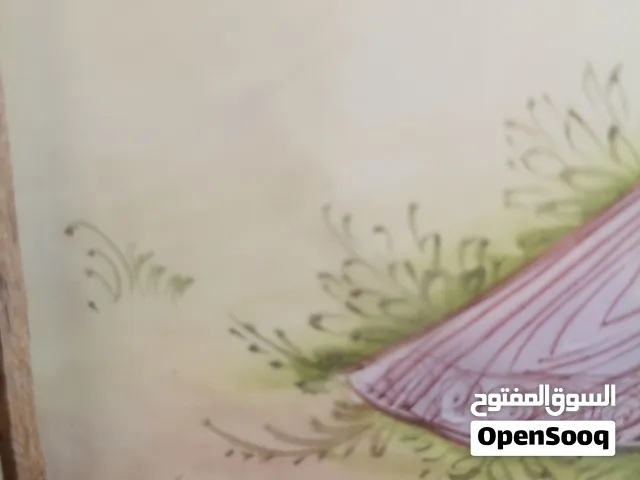 لوحة منمنمة فارسية تقليدية تُصوّر عاشقين بأزياء تراثية، محاطة بإطار هندسي مزخرف بفن الخاتم كاري اليد