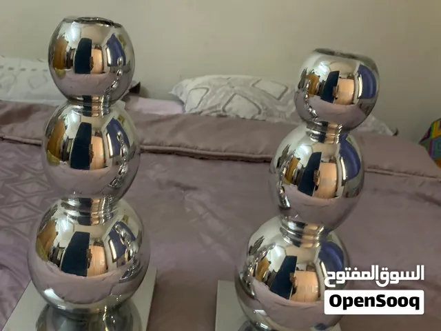 مزهريات وشمعدان على شكل فازة وستاند عرض وفوانيس وستائر