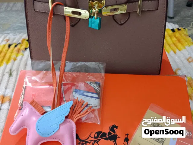 اللون: بني فاتح أو رمادي داكن (Togo Grey/Taupe). الملحقات: غالباً ما تأتي مع قفل، مفاتيح، وحمالة كتف