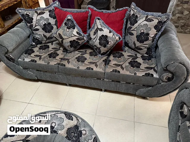 طقم كنب بتصميم جميل ومرتب باللون الرمادي مع نقشة ورود بالأسود والرمادي وتفاصيل أنيقة تعطية شكل فخم