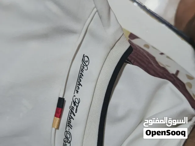 تيشيرت أديداس أصلي باللون الأبيض، بتصميم رياضي أنيق مع تفاصيل باللون الأسود وشعار أديداس. يتميز بخام