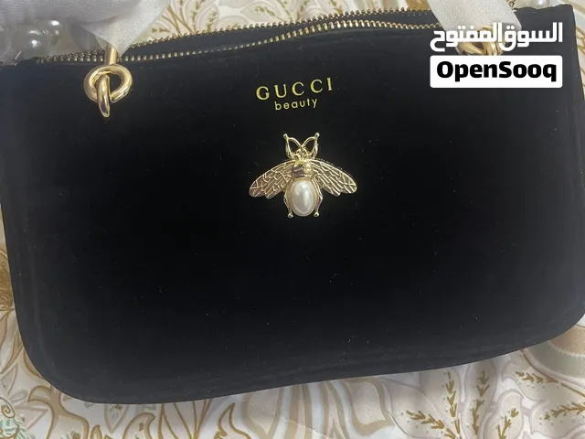 حقيبة مخملية سوداء من Gucci Beauty تتميز بزخرفة ذهبية على شكل نحلة بداخلها لؤلؤة جديده