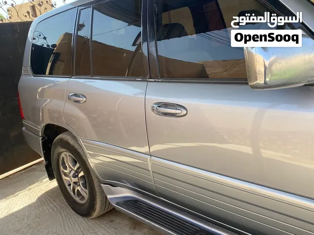 لكزس LX 570 مستعملة موديل 2001 لون أسمنتي مع سبعة مقاعد وفتحة سقف