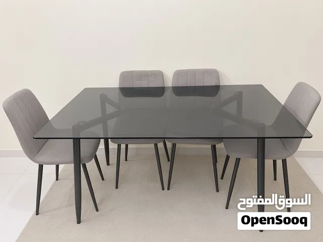 للبيع طاولة طعام من الزجاج المدخن(رمادي غامق) ثقيله و متينه جدا مع 6 كراسي مغطاه بقماش رمادي مريح.