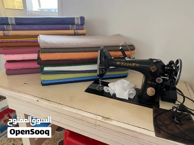 مكينة خياطة مع الطاولة والاقمشة