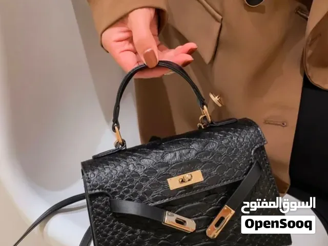حقيبة كتف نسائية بمقبض علوي وتفاصيل معدنية مغطاة بالجلد