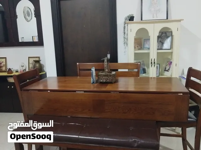 طاولة طعام تتكون من اربع كراسي وواحد طويل من الجلد