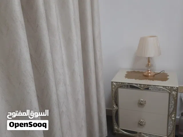 غرفه نوم مكونه من تخت وكومنتين صغار وكمدينه كبيره