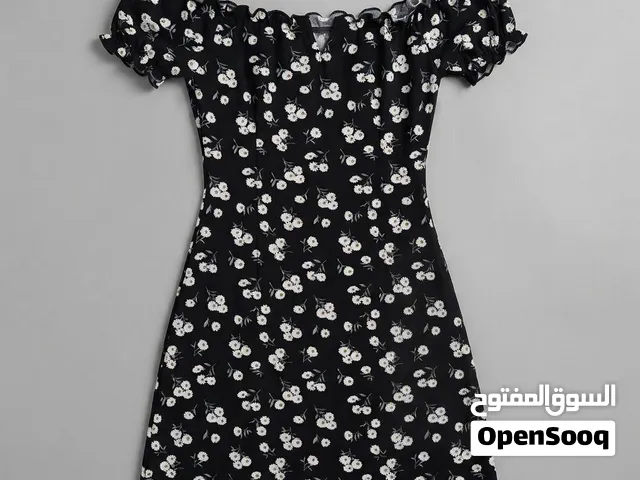فستان صيفي قصير أسود بنقشة ورود ناعمة وأكتاف مكشوفة بطابع أنثوي ناعم