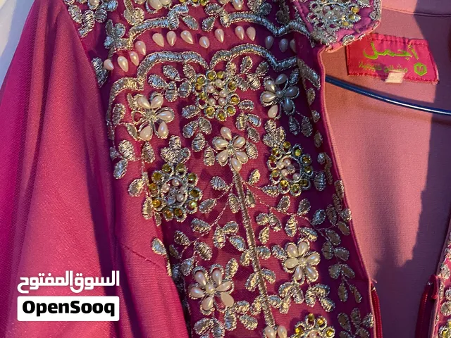 فستان زهري مطرز بالمسات طويل ويوجد حزام من نفس الموديل