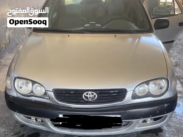 تويوتا كورولا 2000 موديل صالون فضي مستعملة بحالة ممتازة مع أنوار نهارية وداخل جلدية