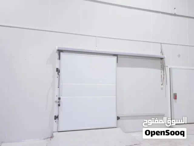 A warehouse equipped with three refrigerators for storage and space for packaging.