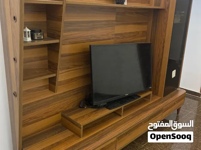 طاولة شاشة لون خشبي شبه جديده موجود بيها رفوف وباب مرش وادرج