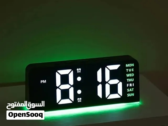 ساعة رقمية مكتبية بشاشة LED كبيرة وأرقام واضحة، مع إضاءة محيطية سفلية ملونة (تظهر باللون الأخضر