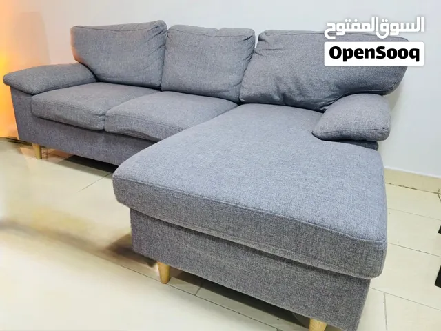 JYSK L-shaped right facing chaise. Upholstered grey woven fabric, wooden legs