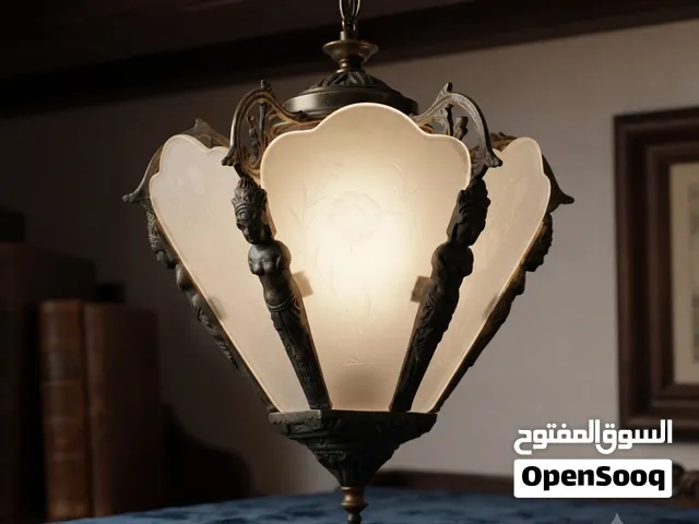 هذه الثريا هي مصباح قلادة قوطي عتيق يتميز بإطار نحاسي مزخرف بزخارف على شكل تماثيل وزجاج مصنفر بنقوش