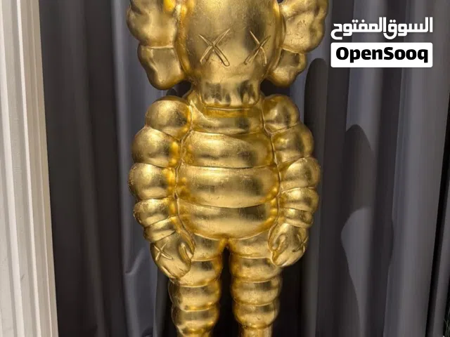 Gold kaws doll on marble glass base