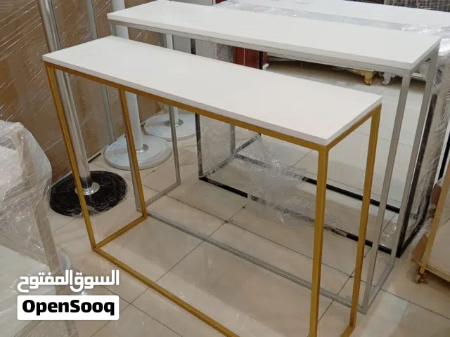 طاولة كونسول عصرية بتصميم هندسي نحيف وقاعدة معدنية ذهبية مع سطح أبيض أنيق