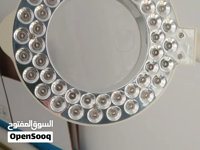 طاولة من الستانلس  والزجاج ذات 3 رفوف زجاج واباجورة ذات اضاءة جميلة