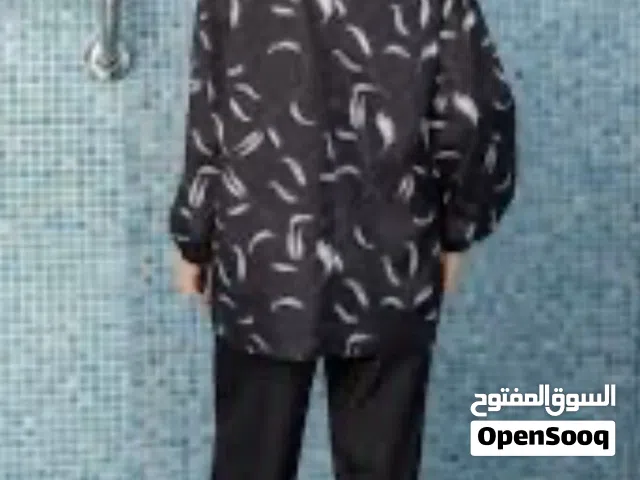 بوركيني للسباحة من ماركة مودانيسا، يتميز بتصميم أسود مع طبعات أوراق شجر بيضاء